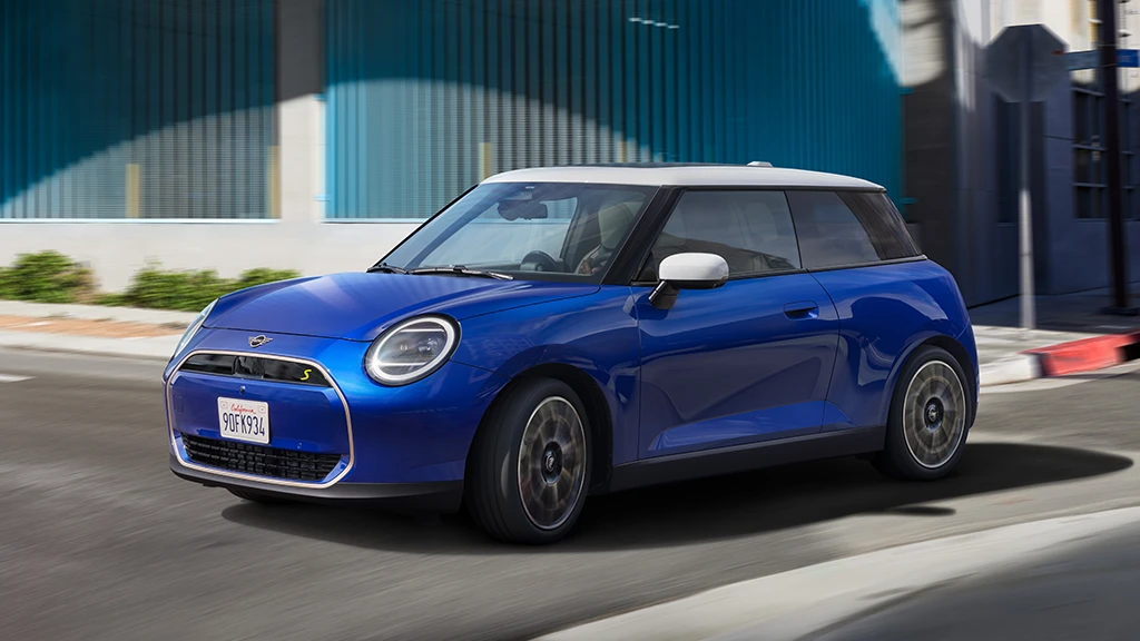 MINI Cooper 3 portes roulant dans une rue urbaine.