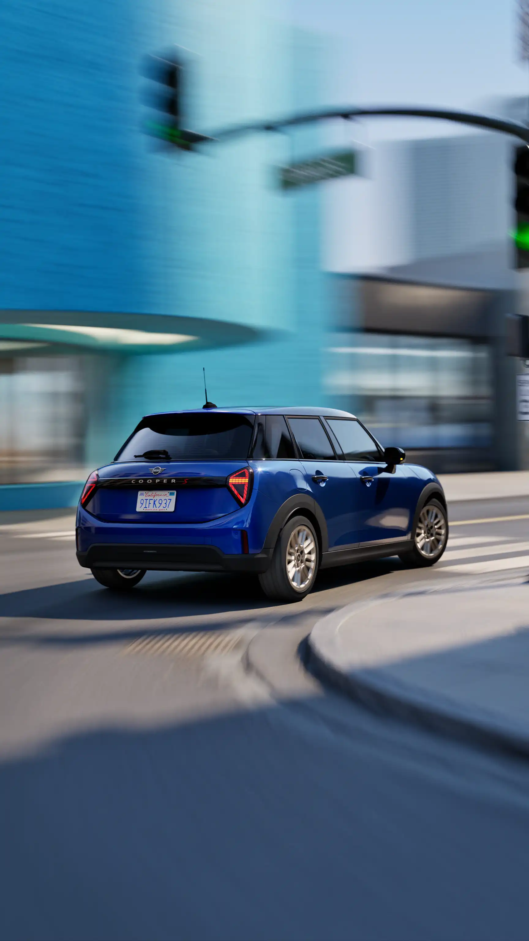 Vue arrière trois quarts d’un MINI Cooper 5 portes traversant une intersection urbaine.